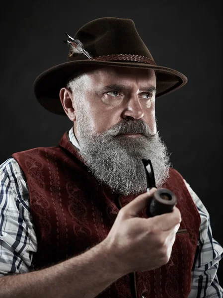 Dramatic portrait of senior smoking tobacco pipe — Stock Photo, Image