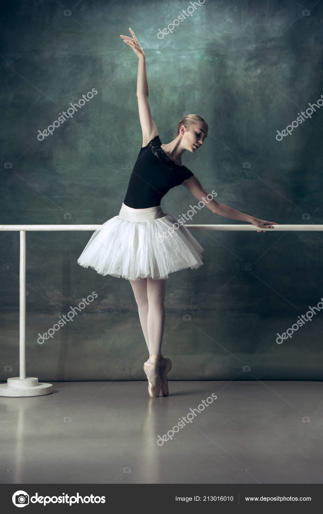 La bailarina clásica posando en la barra de ballet — Foto de stock
