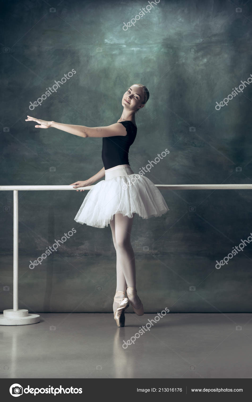 La bailarina clásica posando en la barra de ballet — Foto de stock