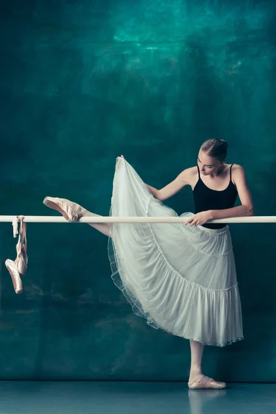 A bailarina clássica posando no ballet barre — Fotografia de Stock