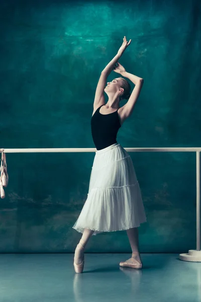 A bailarina clássica posando no ballet barre — Fotografia de Stock