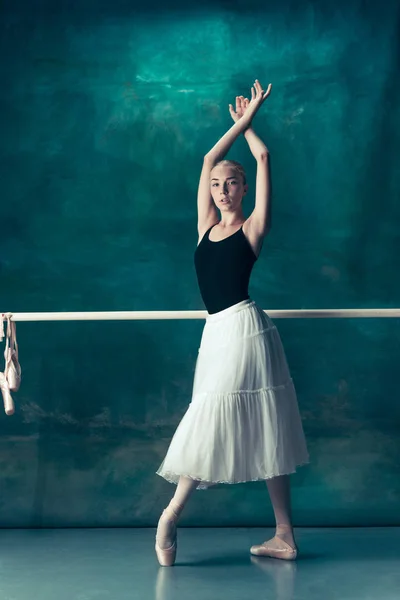 A bailarina clássica posando no ballet barre — Fotografia de Stock