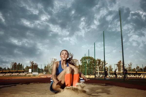 여자 선수는 경쟁 하는 동안 긴 점프를 수행 — 스톡 사진