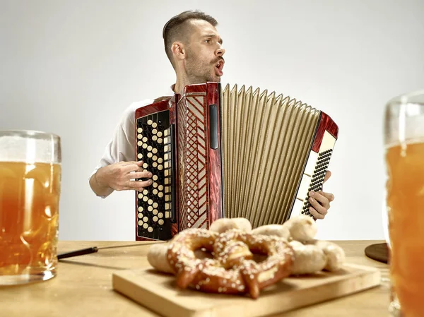 Людина в традиційному баварському одязі грає на акордеоні. Октоберфест — стокове фото
