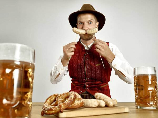 Germany, Bavaria, Upper Bavaria, man with beer dressed in traditional Austrian or Bavarian costume