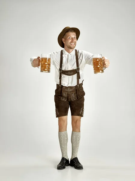 啤酒节的年轻人在帽子 穿着传统的巴法力亚的衣服站在全长的酒室 啤酒节 节日概念 — 图库照片