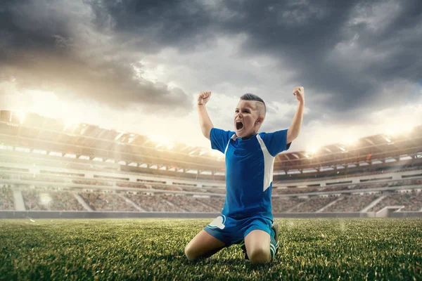 Ung pojke med fotboll gör flygande kick på stadion — Stockfoto