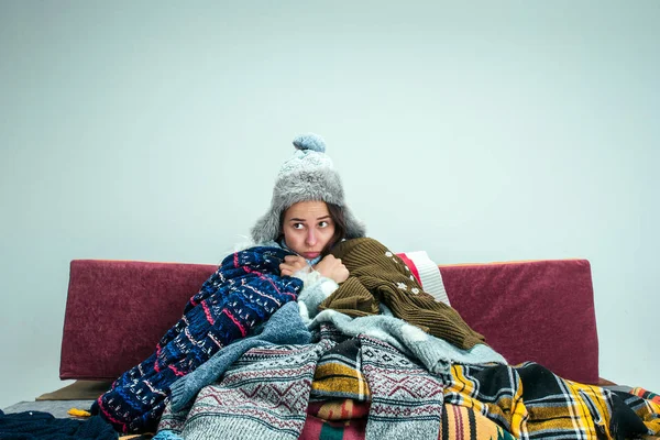 Die junge Frau mit dem Schornstein zu Hause auf dem Sofa sitzend. Gesundheitskonzepte. — Stockfoto