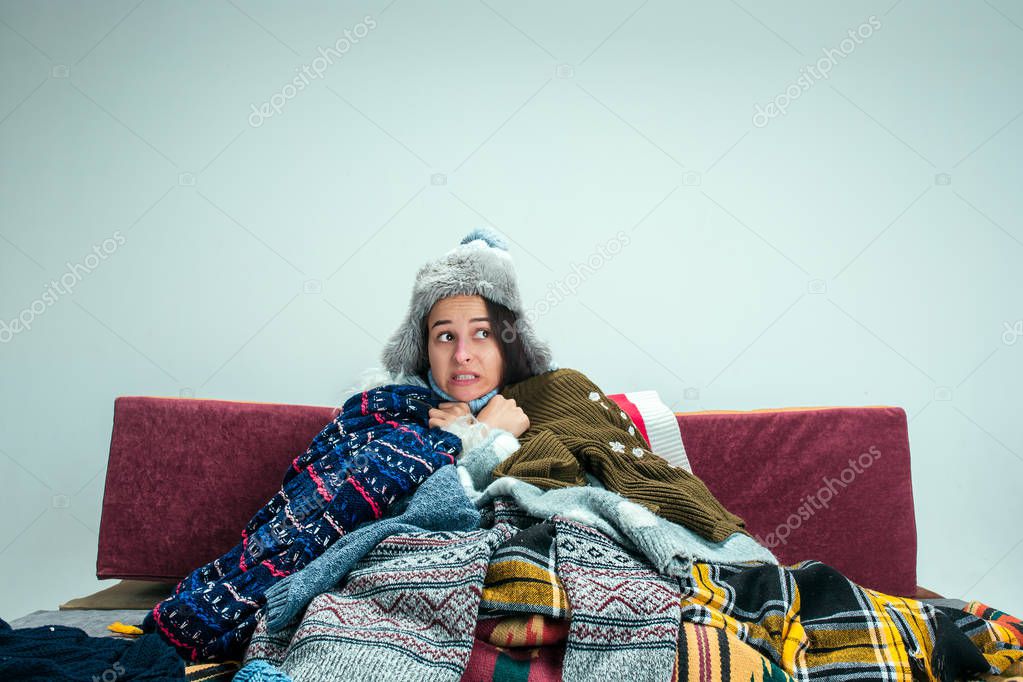 The young woman with Flue Sitting on Sofa at Home. Healthcare Concepts.