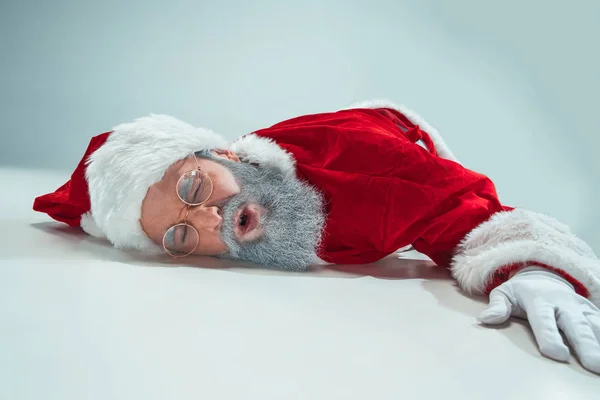 Rojo blanco santa claus sobrecargado frustración burnout concepto acostado en el suelo aislado sobre fondo blanco — Foto de Stock