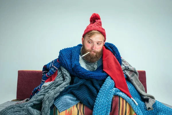 Бородатого мужчини з димових, сидячи на дивані у себе вдома. Концепції охорони здоров'я. — стокове фото