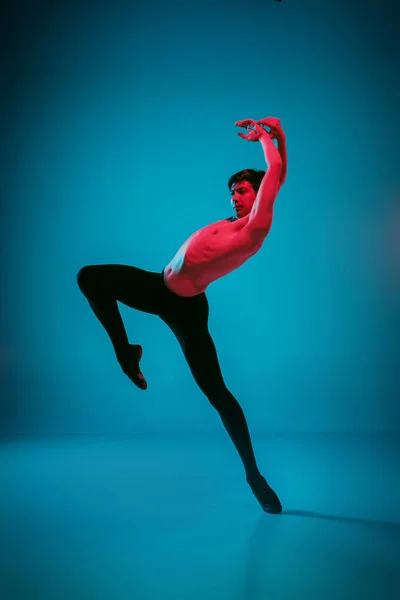 De mannelijke atletische balletdanser uitvoeren van dans op blauwe achtergrond. Studio opname. Ballet concept. Fitte jongeman. Kaukasische model — Stockfoto