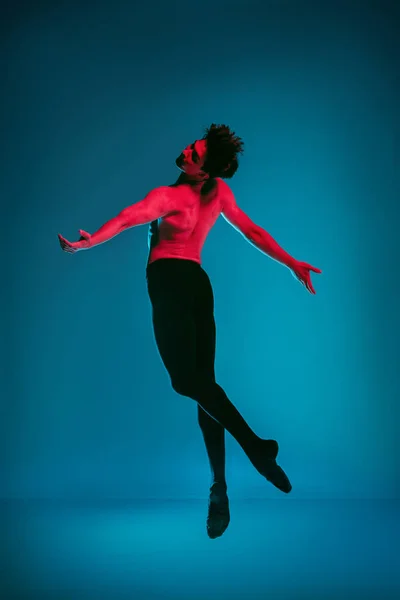 De mannelijke atletische balletdanser uitvoeren van dans op blauwe achtergrond. Studio opname. Ballet concept. Fitte jongeman. Kaukasische model — Stockfoto