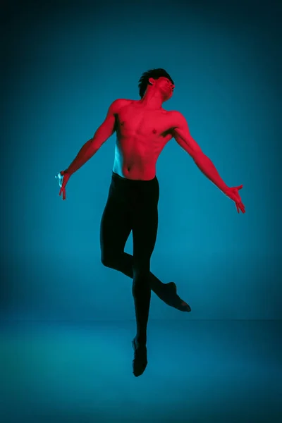 Mužské atletické baletní tanečník provedením tanec na modrém pozadí. Studio záběr. Koncepce baletu. Přizpůsobit mladý muž. Kavkazská model — Stock fotografie