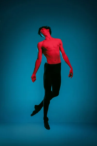 Męskie sportowe tancerz wykonuje taniec na niebieskim tle. Strzał studio. Koncepcja baletu. Fit młody człowiek. Kaukaski modelu — Zdjęcie stockowe