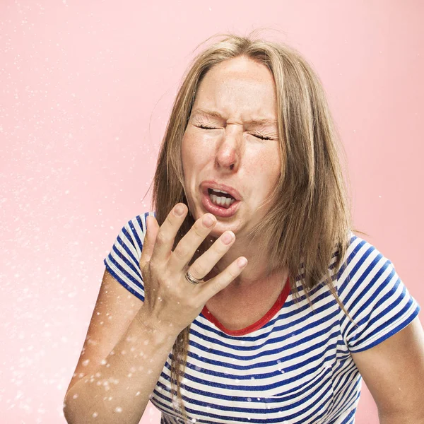 Young woman sneezing, studio portrait — Stock Photo, Image