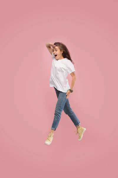 Libertad de movimiento. Mujer bastante joven saltando sobre fondo rosa — Foto de Stock