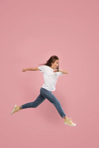 自由移动。漂亮的年轻女子跳对粉红色的背景 — 图库照片