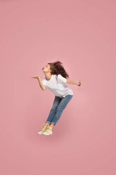 Frihet i rörelse. Ganska ung kvinna hoppa mot rosa bakgrund — Stockfoto