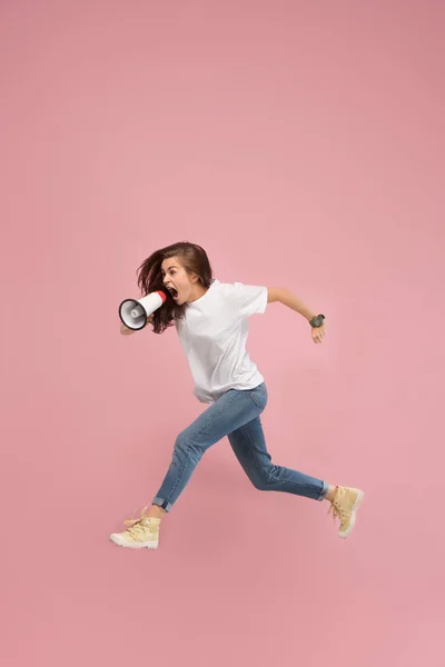 Mulher bonita pulando com megafone isolado sobre fundo rosa — Fotografia de Stock