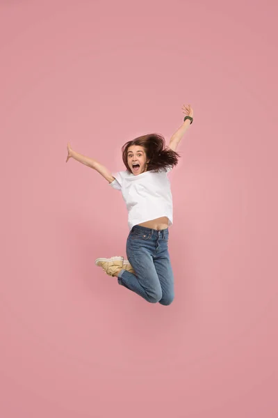 Szabadság mozgó. Csinos, fiatal nő, rózsaszín háttérrel ugrás — Stock Fotó