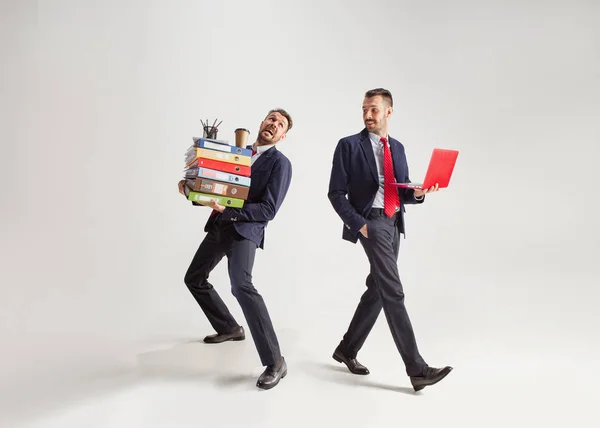 Junger Geschäftsmann im Anzug jongliert mit Büromaterial in seinem Büro, isoliert auf weißem Hintergrund — Stockfoto