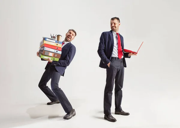 Junger Geschäftsmann im Anzug jongliert mit Büromaterial in seinem Büro, isoliert auf weißem Hintergrund — Stockfoto