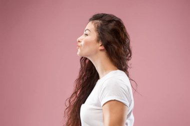 Ayakta ve pembe bir arka plan karşı gülümseyerek mutlu bir iş kadını.