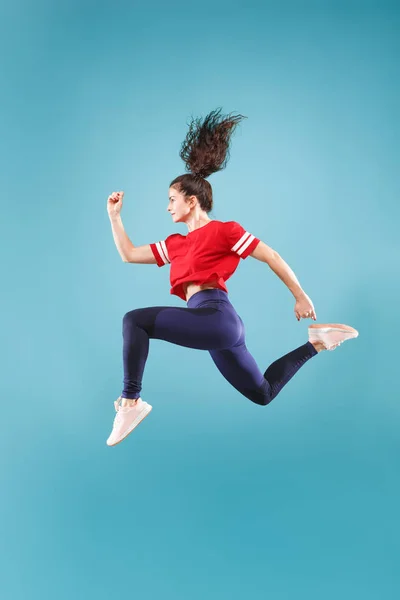 Liberdade em movimento. Mulher muito jovem pulando contra fundo rosa — Fotografia de Stock