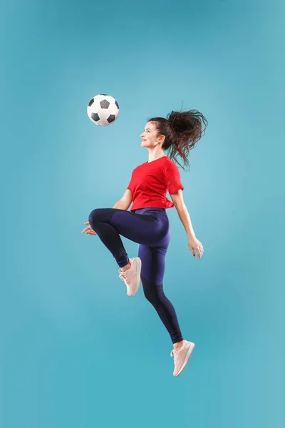 Avanti alla vittoria.La giovane donna come giocatore di calcio che salta e calcia la palla in studio sul rosa — Foto Stock