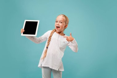Küçük kız mavi zemin üzerine tablet ile