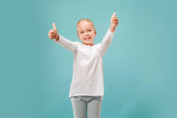 The happy teen girl standing and smiling against blue background. — Stock Photo, Image