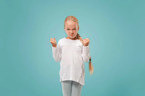 Portret van boze tiener meisje op een blauwe studio achtergrond — Stockfoto