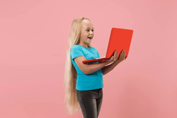 El niño feliz con el portátil rojo sobre rosado — Foto de Stock
