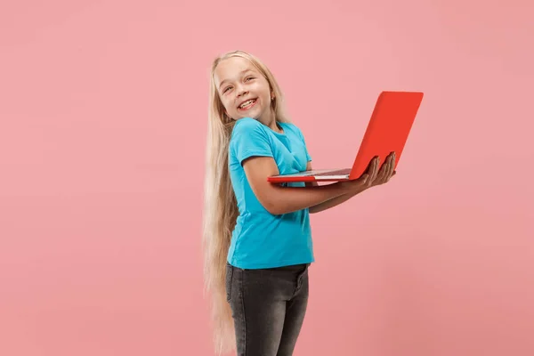 El niño feliz con el portátil rojo sobre rosado — Foto de Stock