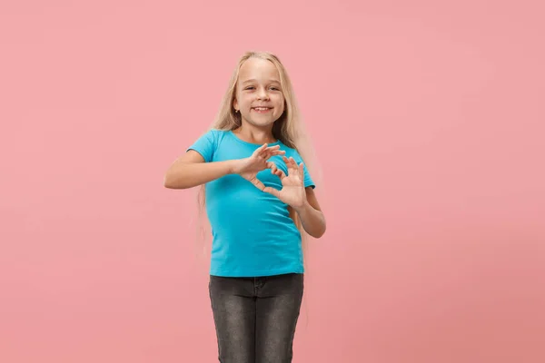 Όμορφη χαμογελαστό κορίτσι έφηβος κάνει το σχήμα του μια καρδιά με τα χέρια σε ροζ φόντο. — Φωτογραφία Αρχείου