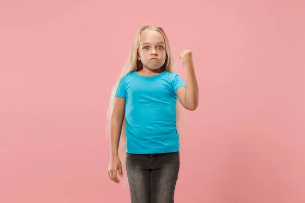 Portret van boze tiener meisje op een roze studio achtergrond — Stockfoto