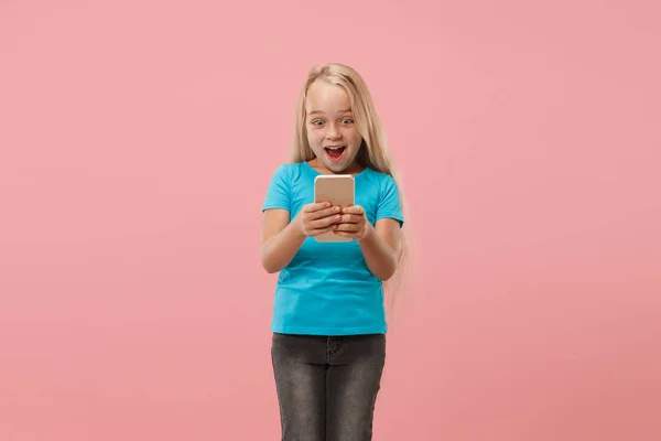La chica adolescente feliz de pie y sonriendo contra el fondo rosa . — Foto de Stock