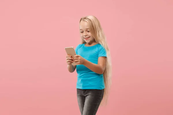 La chica adolescente feliz de pie y sonriendo contra el fondo rosa . — Foto de Stock