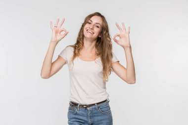 Ayakta ve beyaz arka planı gülümseyerek mutlu bir iş kadını.