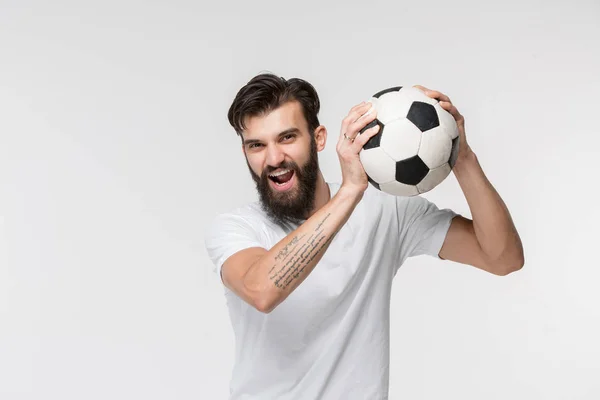 Jovem jogador de futebol com bola na frente do fundo branco — Fotografia de Stock
