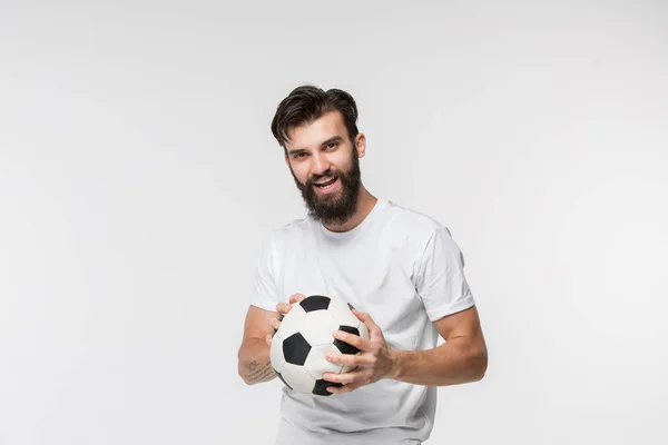 Joven futbolista con pelota delante de fondo blanco — Foto de Stock