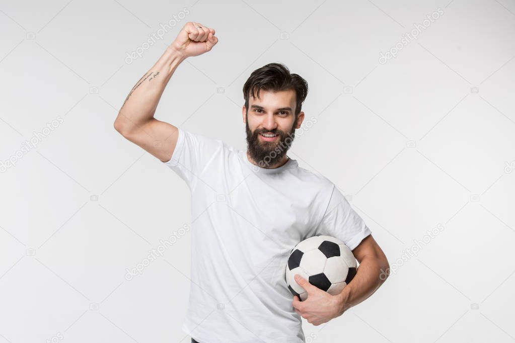 Young soccer player with ball in front of white background
