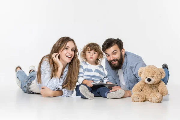 Familia sonriente sentados juntos en el estudio y viendo sus dibujos animados favoritos en el ordenador portátil — Foto de Stock