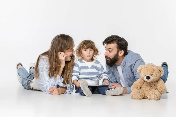 Familia sonriente sentados juntos en el estudio y viendo sus dibujos animados favoritos en el ordenador portátil — Foto de Stock