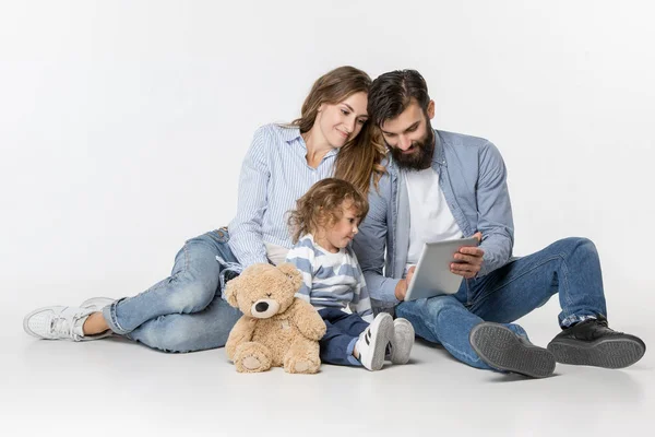 Familia sonriente sentados juntos en el estudio y viendo sus dibujos animados favoritos en el ordenador portátil — Foto de Stock