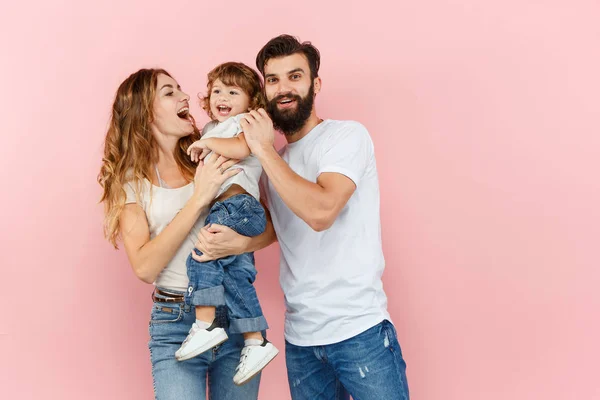 Una familia feliz sobre fondo rosa — Foto de Stock