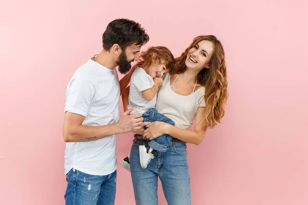 Una familia feliz sobre fondo rosa — Foto de Stock