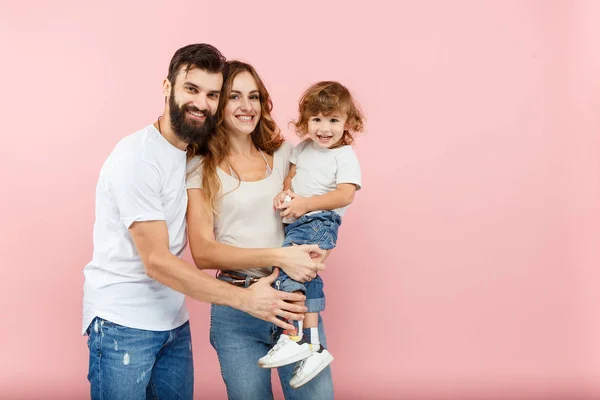 Una familia feliz sobre fondo rosa — Foto de Stock