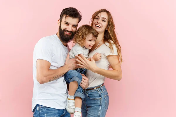 Una familia feliz sobre fondo rosa — Foto de Stock